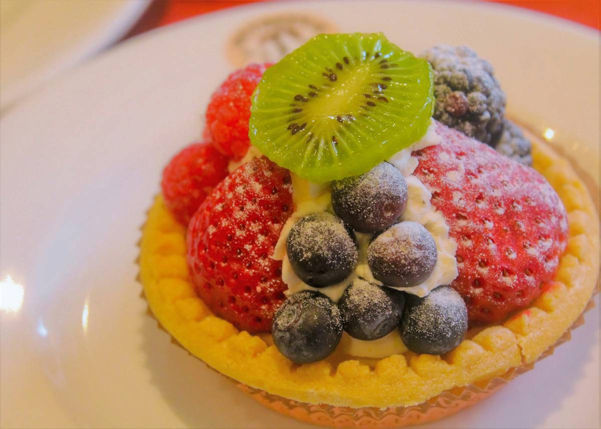 fruit based desserts top 7: colorful arrangement of raw fruit tarts, chia puddings, and berry parfaits